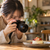 明るい単焦点レンズでデザートを撮影する日本人女性