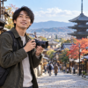 旅行先の街並みをズームレンズ付きミラーレスカメラで撮影する日本人男性