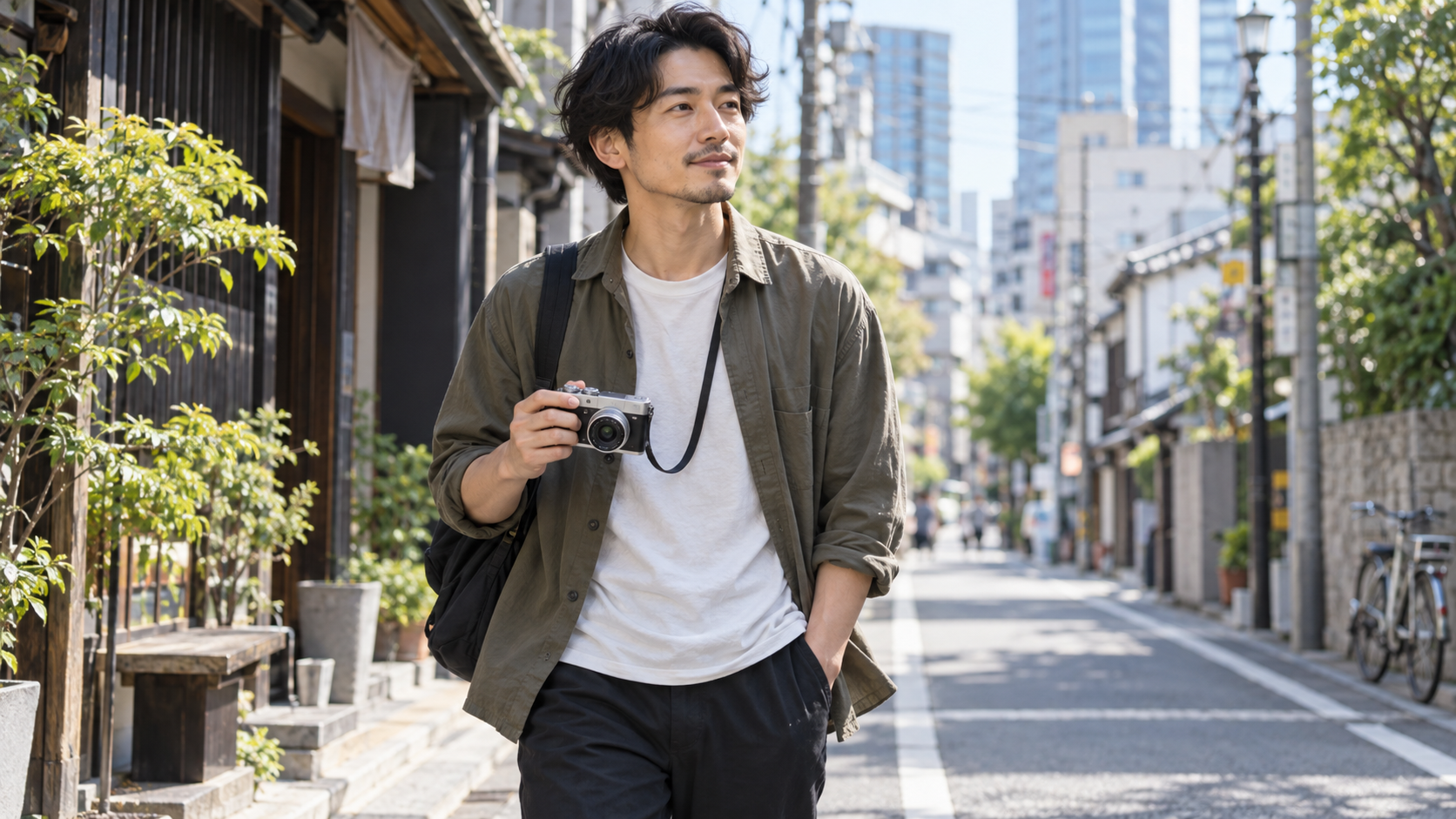 小型ミラーレスカメラと軽量レンズで街歩き撮影をする日本人男性
