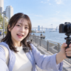 広角レンズ付き小型ミラーレスカメラでVlogを撮影する日本人女性