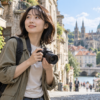 旅行先の街並みでズームレンズ付きミラーレスカメラを持つ日本人女性