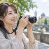 旅行で小型ミラーレスカメラを使って撮影する日本人女性