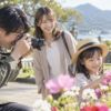 中古カメラで子どもと花を撮影する日本人家族の旅行風景