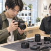 店舗取り寄せした中古カメラと付属品を確認する日本人男性
