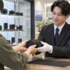 カメラ専門店で中古カメラの店頭買取査定を依頼する様子