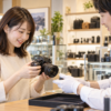 カメラ店で店舗受取した中古カメラの現品を確認する日本人女性