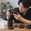 通販で届いた中古カメラの外観と付属品を確認する日本人男性