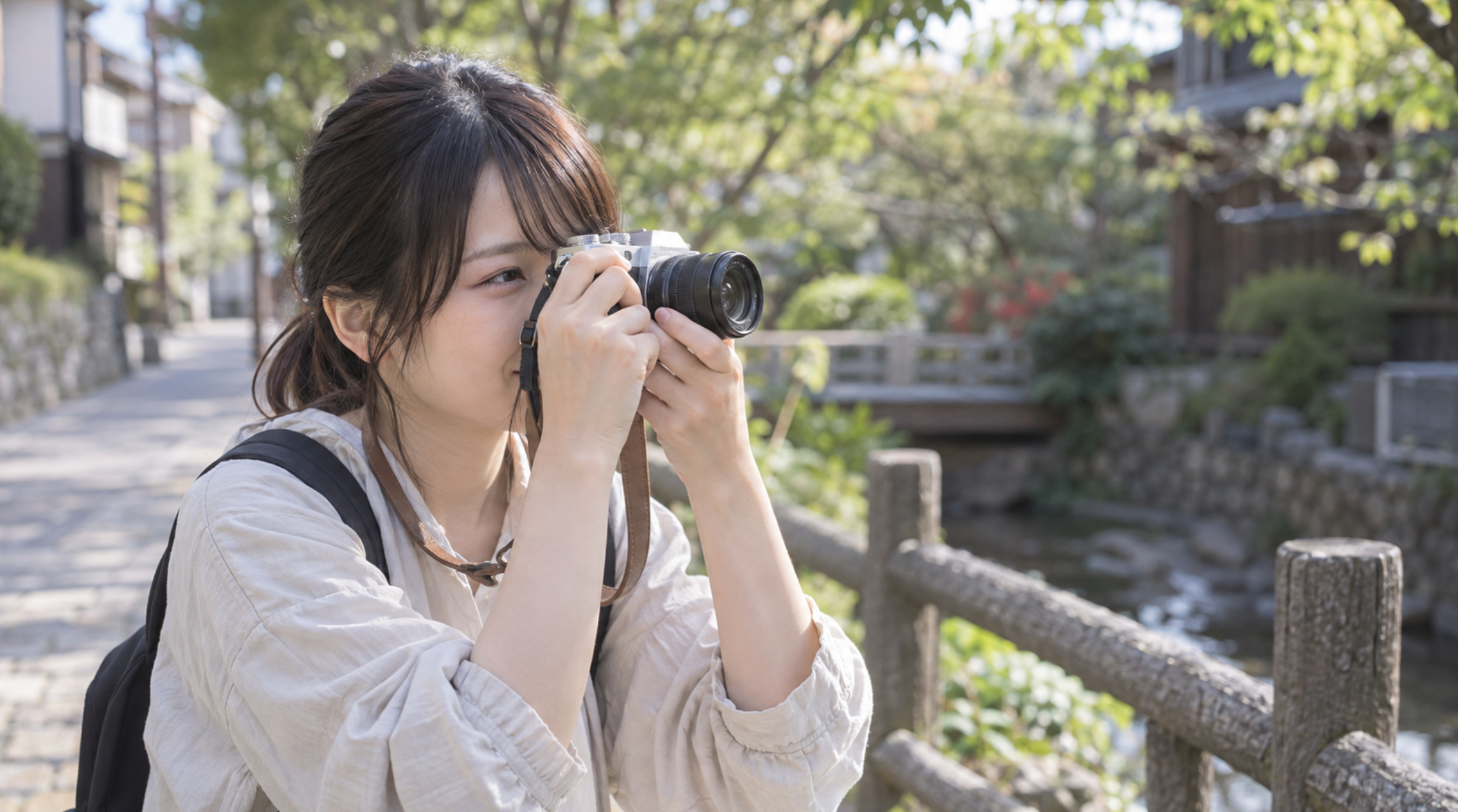 小型ミラーレスカメラを構えて街歩き撮影を楽しむ日本人女性