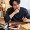 35mmフィルムの店頭現像と郵送現像を比較する日本人男性