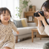 室内で動く子どもをミラーレスカメラで撮影する日本人女性