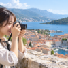 LUMIX G100Dと小型ズームレンズで旅行風景を撮影する女性