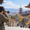 高倍率ズームで寺院の風景を撮影する日本人旅行者